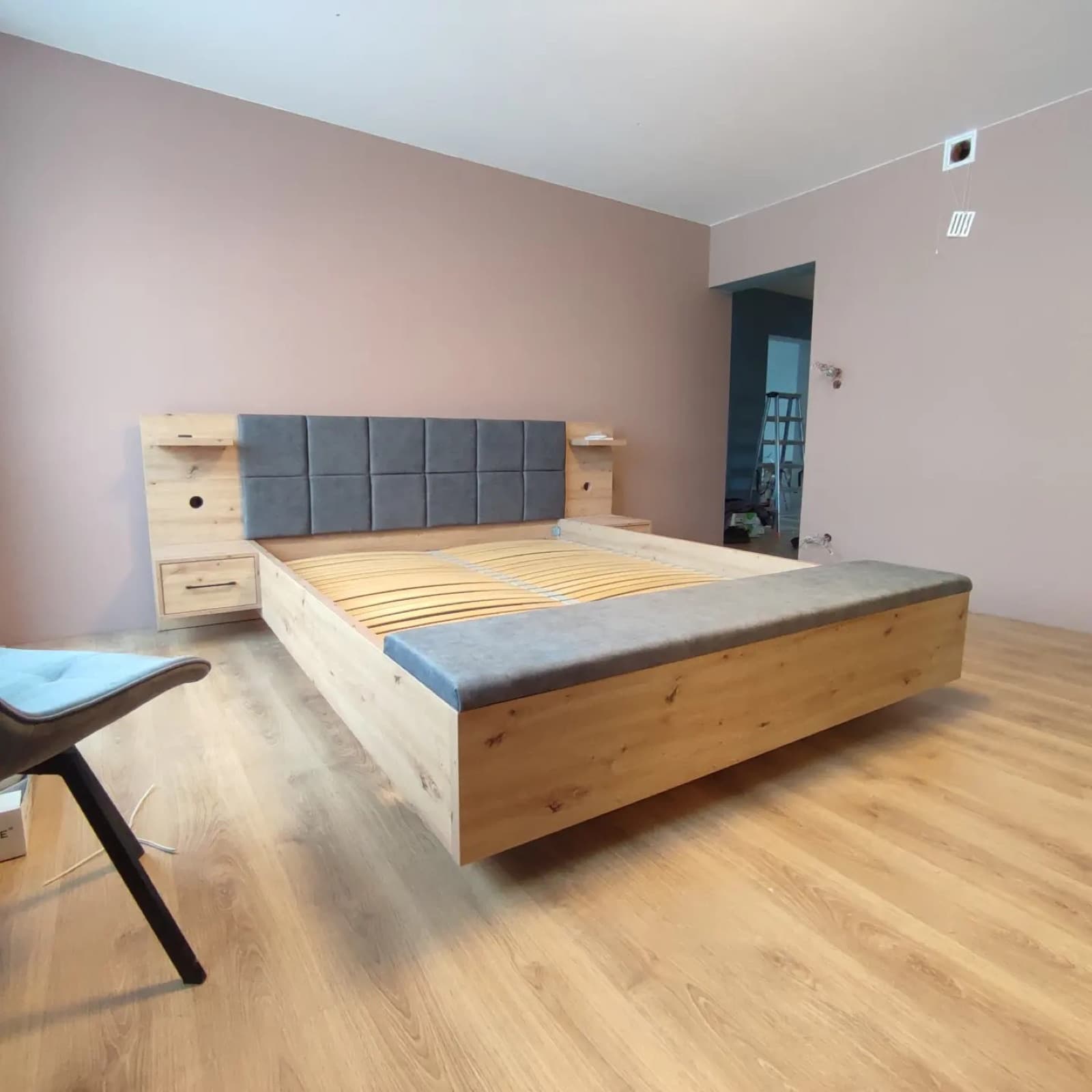 Łóżko z wiszącymi szafkami nocnymi, widok z boku